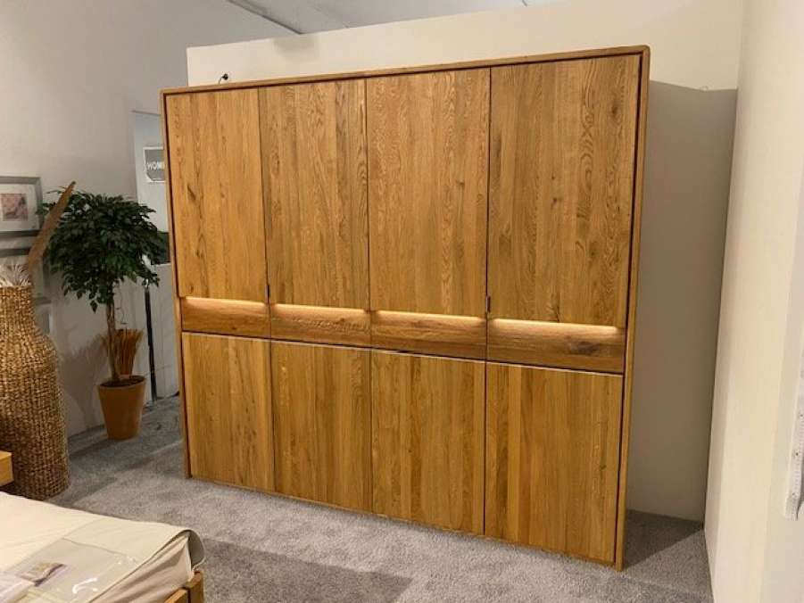 Kleiderschrank aus dunkelem Massivholz in grauen Schlafzimmer